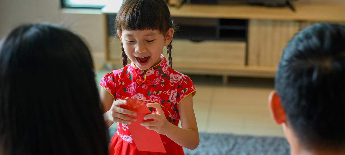 Young girl opening her ang bao happily